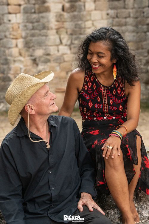 Jinja et Didier Klein assis devant un mur de pierre